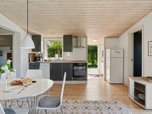 Kjøleskap, ovn, oppvaskmaskin og høy barnestol