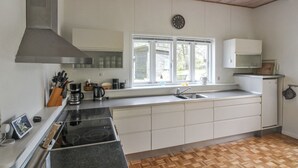 Une cuisine moderne équipée d’une cuisinière, d’un évier et d’une fenêtre.