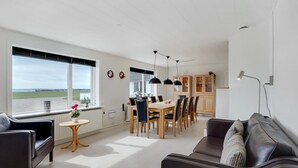 A spacious living area with a dining table, chairs, a sofa, and a view of the outdoors. - "Imilie" - 250m to the fjord by Interhome (Redsted Mors)
