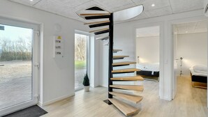 A modern interior with a spiral staircase, a bed, and a bathroom. - "Markhild" - 300m to the fjord by Interhome (Hurup Thy)