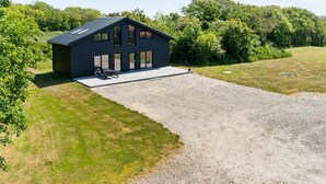 A modern house with a large patio and a gravel driveway. - "Markhild" - 300m to the fjord by Interhome (Hurup Thy)