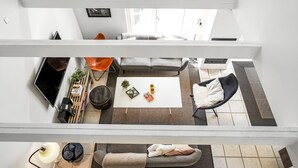 Een moderne woonkamer met een flatscreen televisie, een bijzettafeltje en een bank.