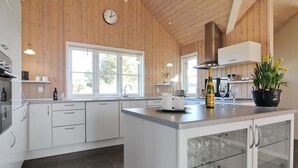 Une cuisine moderne avec des murs en bois, une grande fenêtre et un meuble à vin.