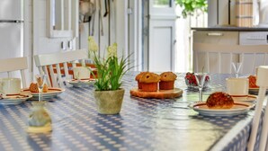 Uma mesa de jantar posta com pratos, xícaras e um vaso de planta.