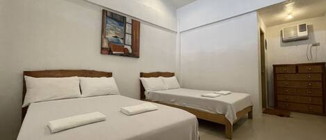 Habitación de hotel con dos camas, un cuadro en la pared y un aparador.