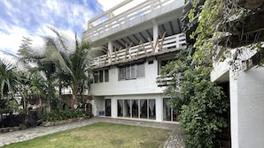 A modern two-story building with a flat roof, large windows, and a covered outdoor area. - Akkaw Baler Hometel (Baler)