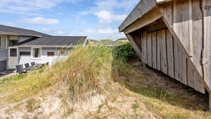 A coastal building with a sloped roof, adjacent to a sandy area with vegetation. - "Kulle" - 200m from the sea by Interhome (Saltum)