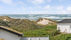 A coastal view with a sandy beach, dunes, and a white building with a dark roof. - "Kulle" - 200m from the sea by Interhome (Saltum)