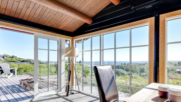 Ein geräumiger Balkon mit Holzboden, einem Tisch mit Tassen und einem Stuhl.