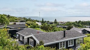 Ein Wohngebiet mit Häusern, einem Fahnenmast und Blick auf das Meer.