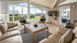 Un salón amplio con techo alto, ventanas grandes y chimenea.