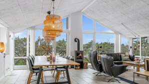 Una habitación amplia con una gran mesa de comedor, sillas de cuero negro y una chimenea.