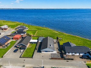 Un quartier résidentiel avec des maisons, une route et une étendue d’eau.