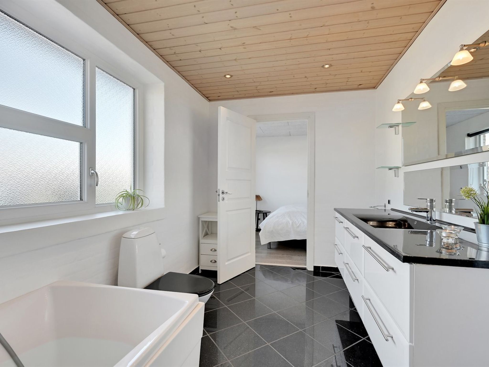 Et moderne badeværelse med badekar, toilet og håndvask.