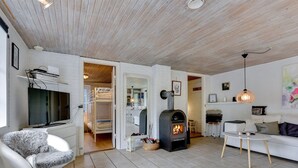 Un salon moderne avec une cheminée, un canapé, un téléviseur et un coin lecture confortable.