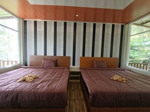 A room with two beds, each with a wooden headboard and a purple bedspread. There is a window on the left side, and a curtain with vertical stripes is visible behind the beds. - Pijar Resort Powered by Cocotel (Colo)