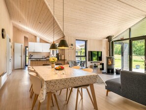 A modern interior with a dining area, kitchen, and a fireplace.