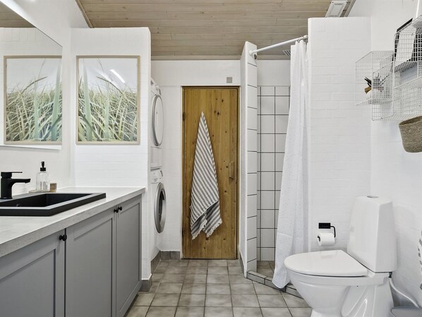 Un baño moderno con lavabo, inodoro y ducha.