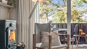 A cozy room with a wood-burning stove, a comfortable chair, and a dining table. - "Apsolon" - 600m from the sea by Interhome (Løkken)