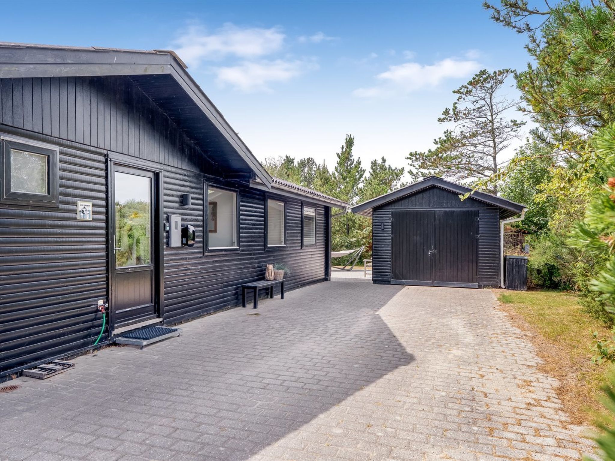 A modern building with a brick pathway leading to a covered outdoor area.