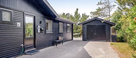 A modern building with a brick pathway leading to a covered outdoor area.