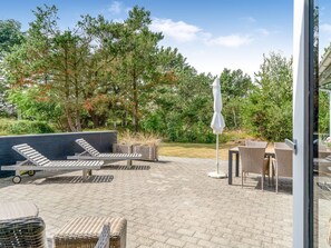 An outdoor patio with lounge chairs, a table, and a sun umbrella. - "Barba" - 2km from the sea by Interhome (Blokhus)