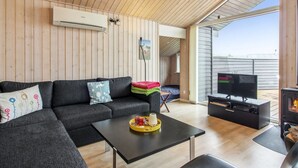 A modern living room with a sectional sofa, a flat-screen TV, and a fireplace. - "Alma" - 500m from the sea by Interhome (Løkken)