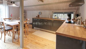 Een moderne keuken met een houten keukeneiland, roestvrijstalen apparatuur en een groot raam voor natuurlijk licht.