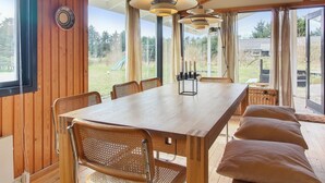 A wooden dining area with a table, chairs, and a candle holder. - "Nestori" - 950m from the sea by Interhome (Løkken)