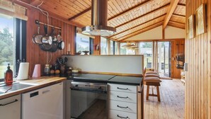 A cozy kitchen with wooden beams, a stove, and a large window. - "Nestori" - 950m from the sea by Interhome (Løkken)