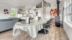 Eine moderne Küche mit Essbereich, einem großen Fenster und einem Gemälde an der Wand.