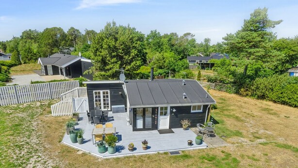 Une maison moderne à deux étages, dotée d’une terrasse, d’un patio couvert et d’une cour clôturée.