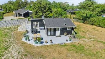 Une maison moderne à deux étages, dotée d’une terrasse, d’un patio couvert et d’une cour clôturée.