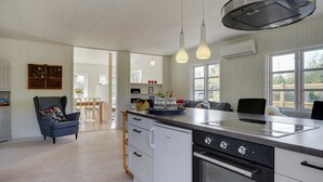 A modern kitchen with a large island, pendant lights, and a built-in oven. - "Aris" - 480m from the sea by Interhome (Ebeltoft)