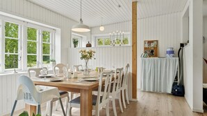 A dining area with a wooden table, white chairs, and pendant lighting. - "Aris" - 480m from the sea by Interhome (Ebeltoft)