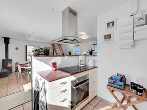 Een koelkast, een magnetron, een vaatwasser, kookgerei, borden en bestek