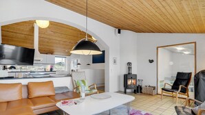 Una sala de estar moderna con una mesa blanca, sofá de cuero y una chimenea.