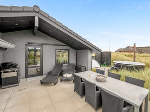 Un espace extérieur aménagé avec une table et des chaises, un barbecue et un jacuzzi.