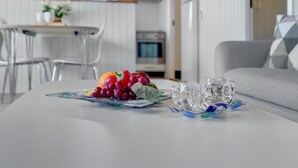 A modern kitchen with white cabinets, a dining area with a white table and chairs, and a living area with a grey sofa. - "Vladan" - 1.6km from the sea by Interhome (Blåvand)