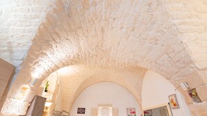 A stone ceiling with an arched doorway, a sign reading 'Welcome,' and a small potted plant. - Holiday Home 'Pietrarosa Loft' with Wi-Fi (Ostuni)