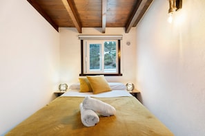 Une chambre à coucher avec un lit, des oreillers, une fenêtre et une serviette sur le lit.