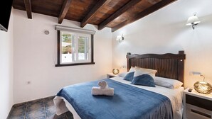 A bedroom with a bed, a window, a nightstand, and a wall-mounted lamp. - Vacation Home "Ático Miranda" with Jacuzzi, Views of El Teide & Wi-Fi (Icod de los Vinos)