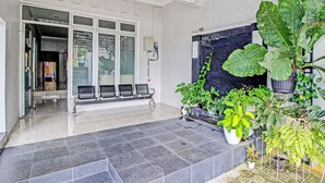 Un área de recepción con suelo de baldosas, un banco y plantas en macetas.
