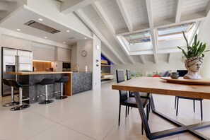 A modern kitchen with a central island, bar stools, and a dining table with chairs. - Apartment 'Castle View' with Mountain View, Balcony and Wi-Fi (Drena)