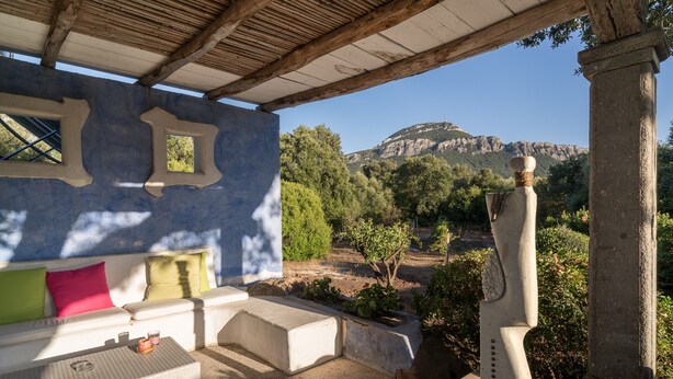 Un espacio de estar techado al aire libre con vistas a un paisaje montañoso.