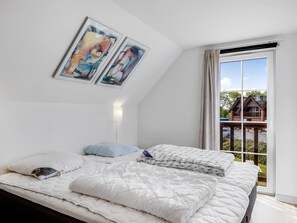 Una camera da letto con un letto, un comodino, una lampada e una finestra vista casa.