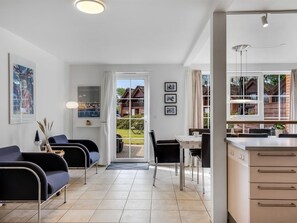 Un intérieur moderne comprenant un coin repas, une cuisine et une vue sur l’extérieur.