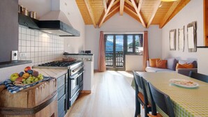 A kitchen with a stove, oven, and a fruit basket on the counter. - Holiday Home 'Pollicina' with Mountain View and Balcony (Margno)