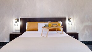 A hotel room with a large bed, bedside tables, a tray with breakfast items, and wall-mounted lamps. - Vacation Home "Las Monarcas" with Mountain View, Private Terrace & Wi-Fi (Teror)