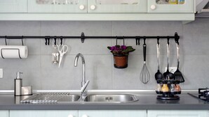 A kitchen with a stainless steel sink, a hanging utensil rack, a roll of paper towels, and a small potted plant. - Vacation Home "Las Monarcas" with Mountain View, Private Terrace & Wi-Fi (Teror)